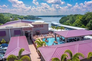 Un hotel frente al lago con piscina, mobiliario exterior y vistas al lago.