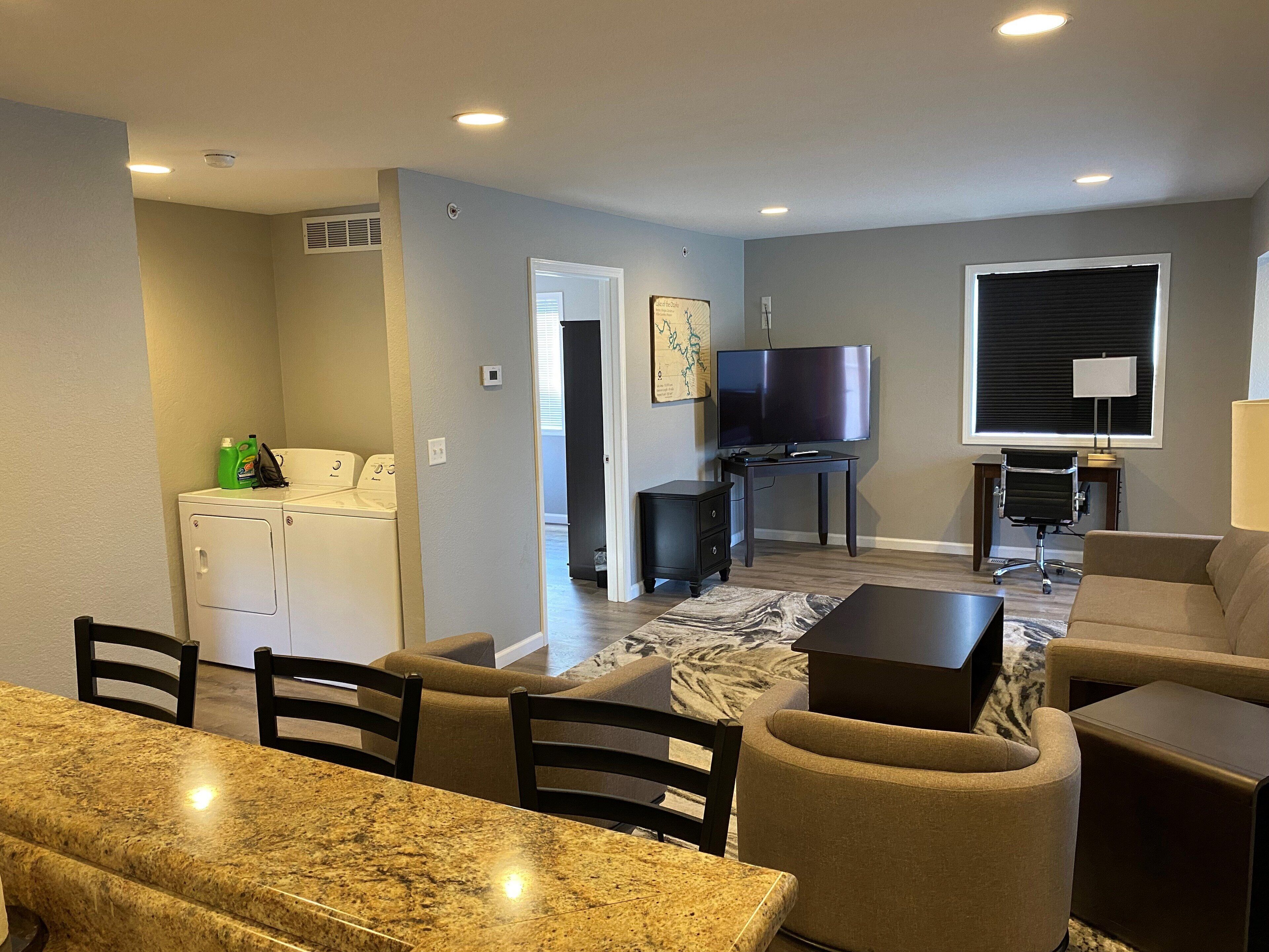 A living room with a TV, sofa, and dining area.