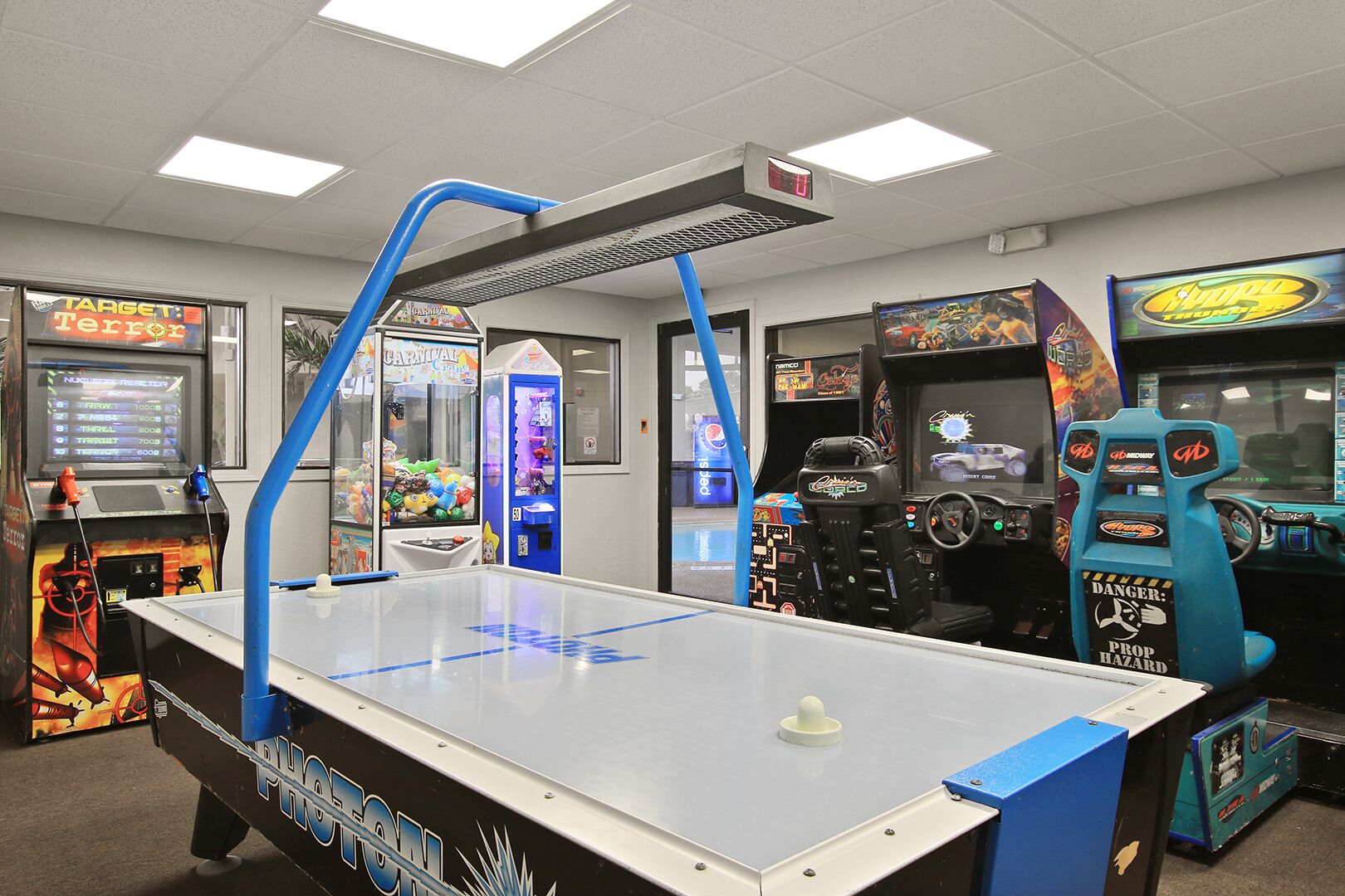 A room with a foosball table, arcade games, and a Target Terror sign.