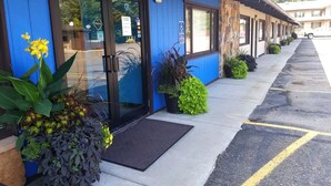 A motel with a blue exterior, a sign reading "OFFICE", and a parking lot with yellow lines.