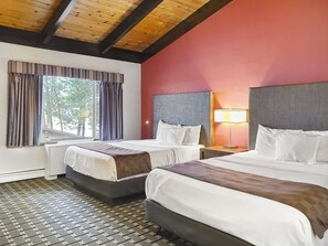 A hotel room with two beds, a window with curtains, a radiator, and a lamp on the nightstand. - Americas Best Value Inn Hinckley (Hinckley)