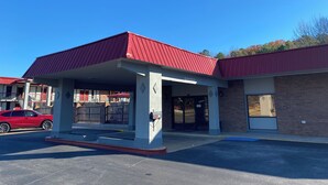 A building with a red roof and a covered entrance area. - Red Roof Inn Jacksonville, AL  (Jacksonville)