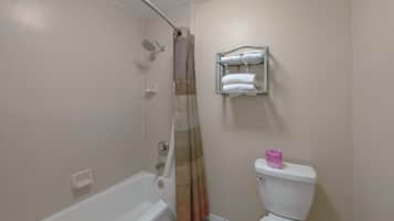 Un baño con bañera, ducha, inodoro y un perchero para toallas.