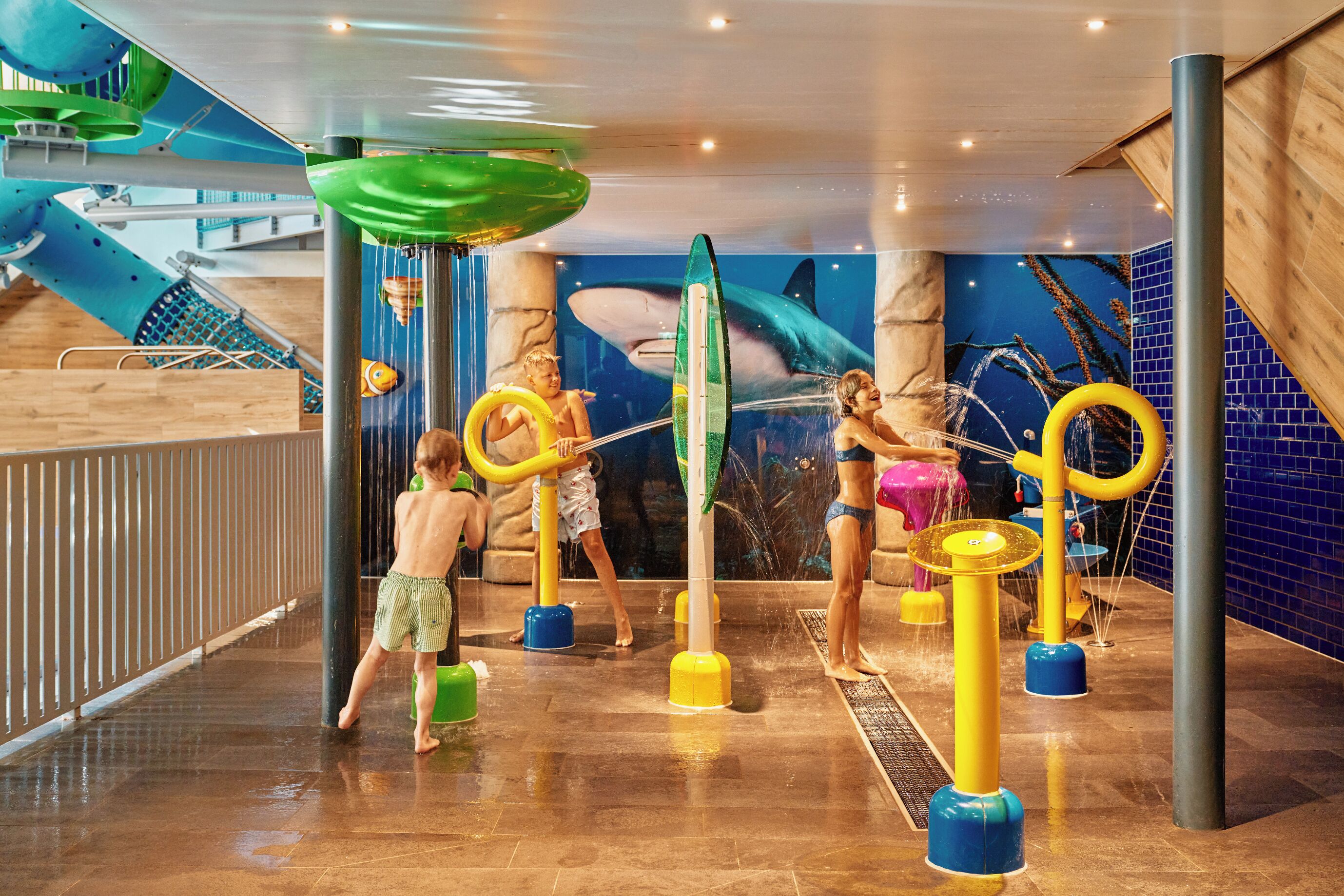 An indoor water play area with slides and water features.