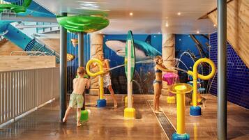 An indoor water play area with slides and water features.
