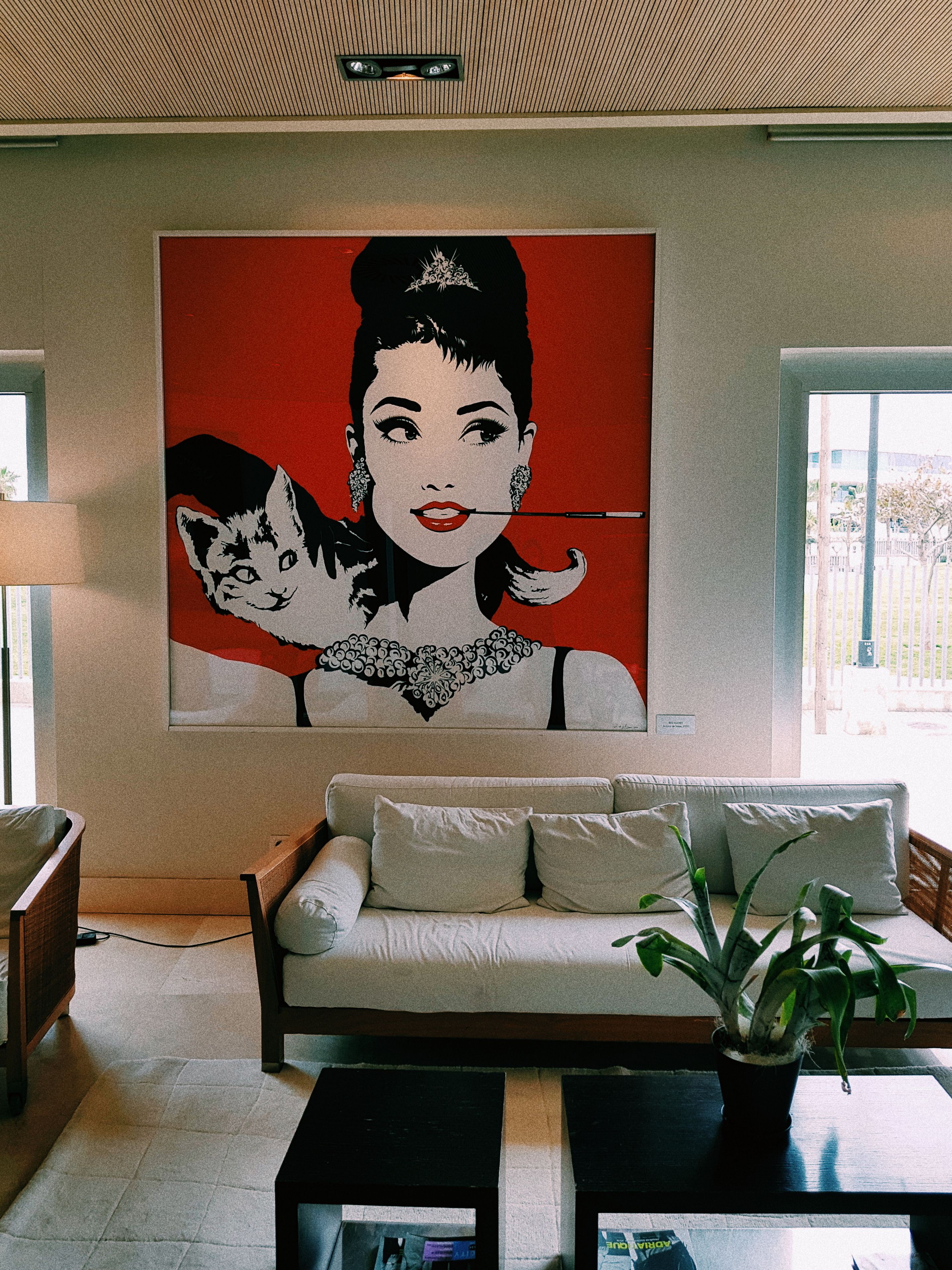A living room with a sofa, a coffee table, and a large painting on the wall.