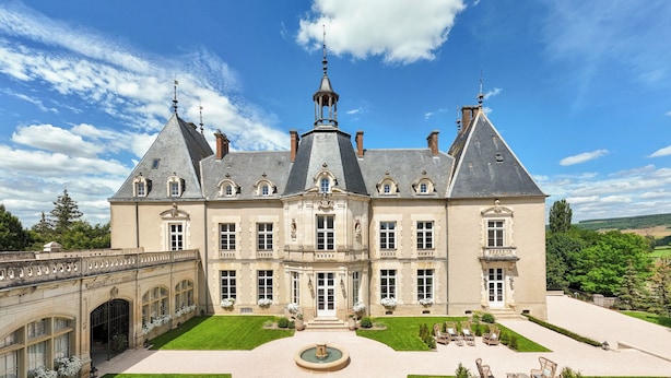 A large, historic building with a symmetrical facade, multiple chimneys, and a central courtyard with a fountain. - Château Sainte Sabine (Sainte-Sabine)