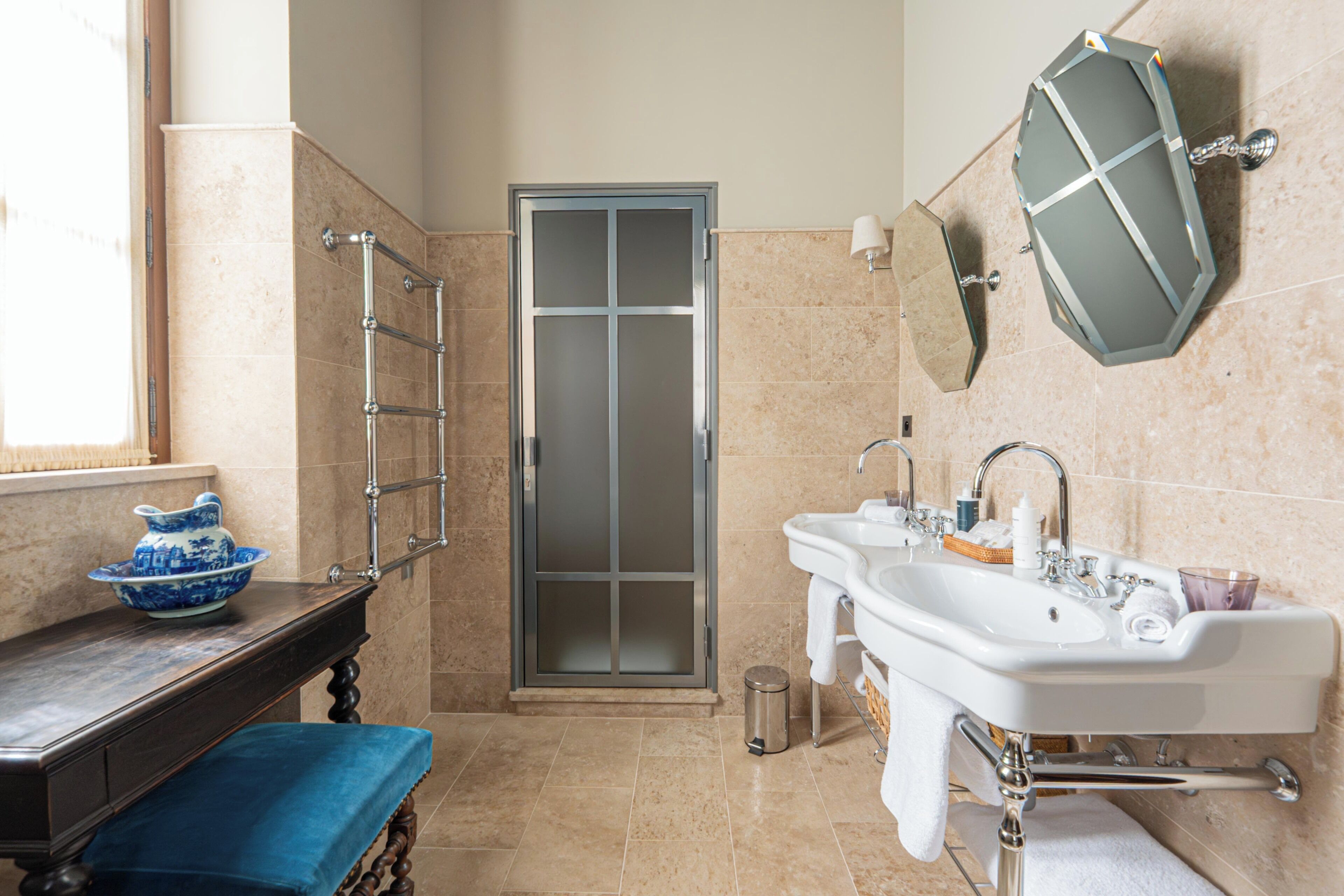 Un baño con lavamanos, espejo, toallero y una puerta.