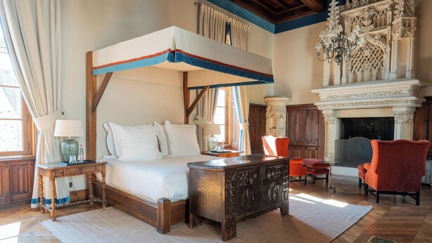 A four-poster bed with a wooden headboard, a fireplace, and a chandelier. - Château Sainte Sabine (Sainte-Sabine)