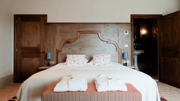 A neatly made bed with a wooden headboard, two pillows, and a bedside table with a lamp.