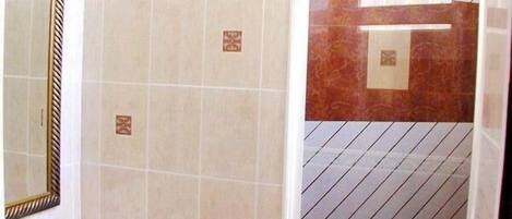 A bathroom with a sink, mirror, and tiled walls.
