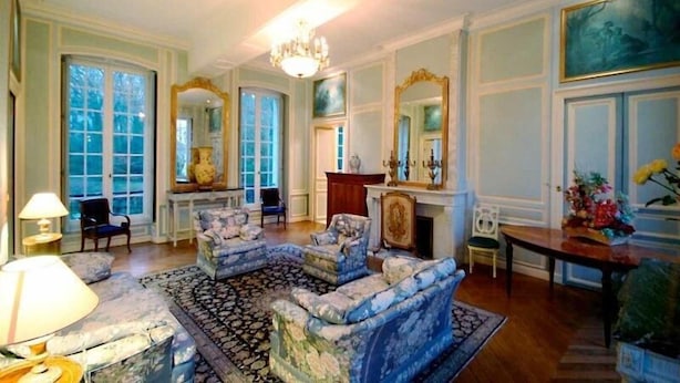 A spacious living room with a large, ornate fireplace, multiple seating areas, and large windows. - Domaine de Moresville (Flacey)