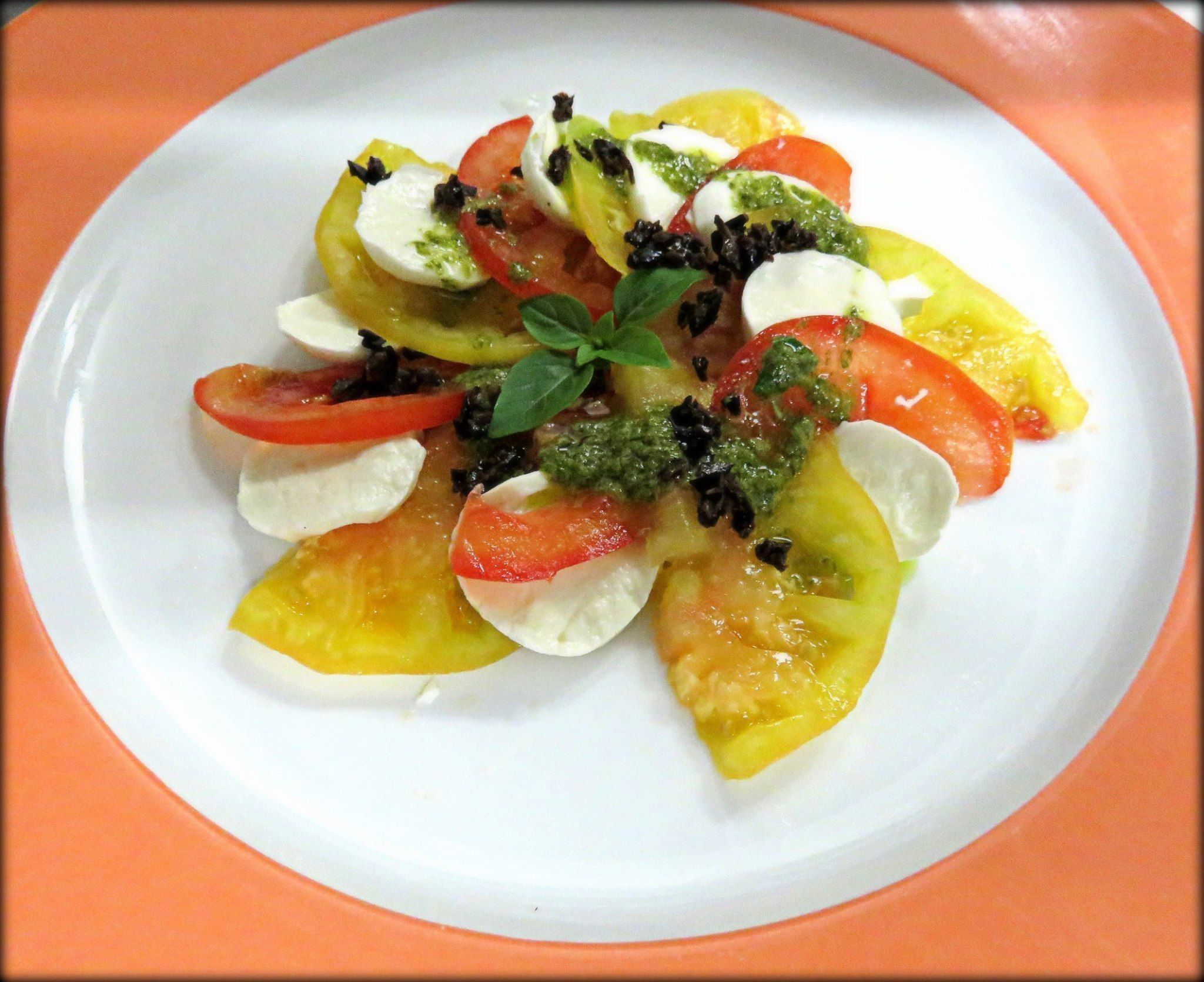 A plate of Caprese salad with tomatoes, mozzarella, and basil.