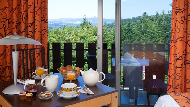 Une table de petit-déjeuner avec vue sur une forêt et des montagnes.