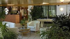 Un espace intérieur moderne comprenant une table de billard, deux fauteuils blancs et une table à manger.