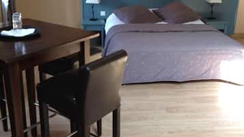 Una habitación de hotel con una cama, una mesa con sillas y una mesita de noche con lámparas.