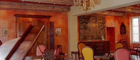 A grand room with a grand piano, a large painting, and a chandelier.