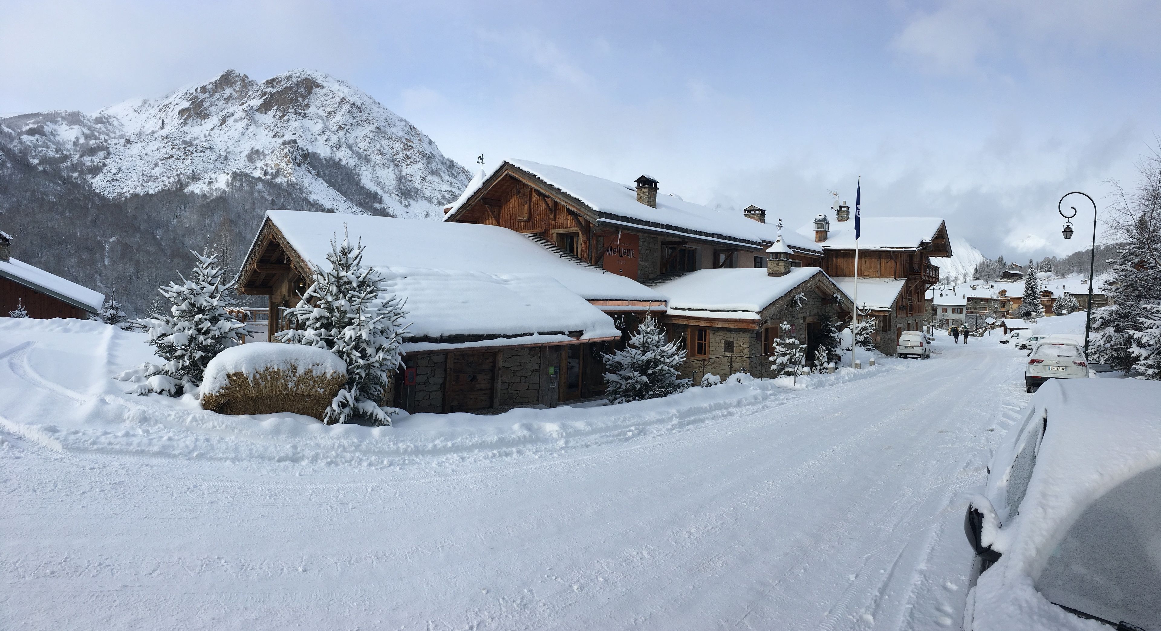 A snow-covered mountain village with wooden buildings and a clear sky.