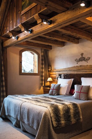 A rustic wooden ceiling with exposed beams and a bed with a fur throw. - Hotel Restaurant La Bouitte - Relais & Châteaux - 2 étoiles Michelin (Les Belleville)