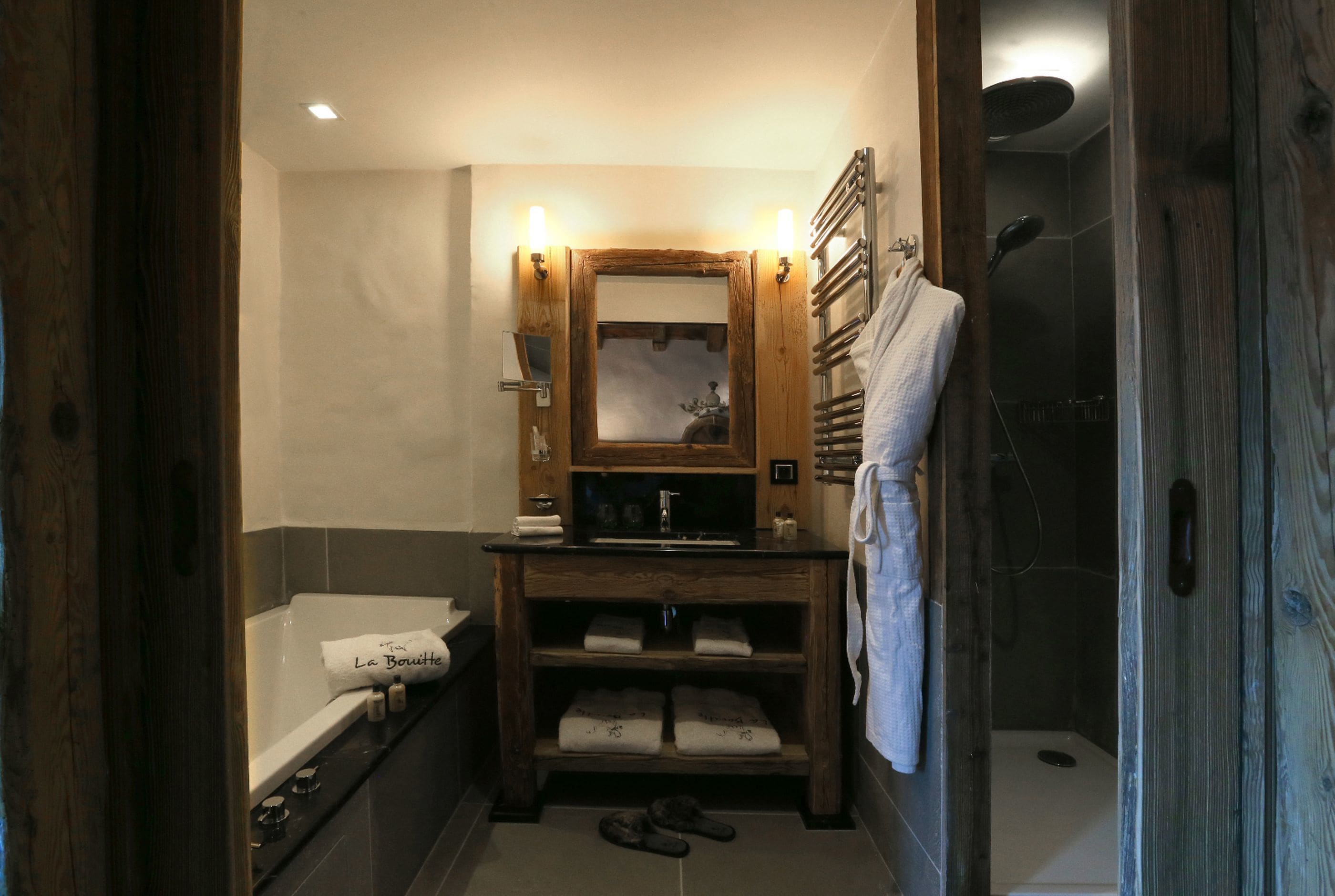 Un baño con tocador de madera, bañera y zona de ducha.