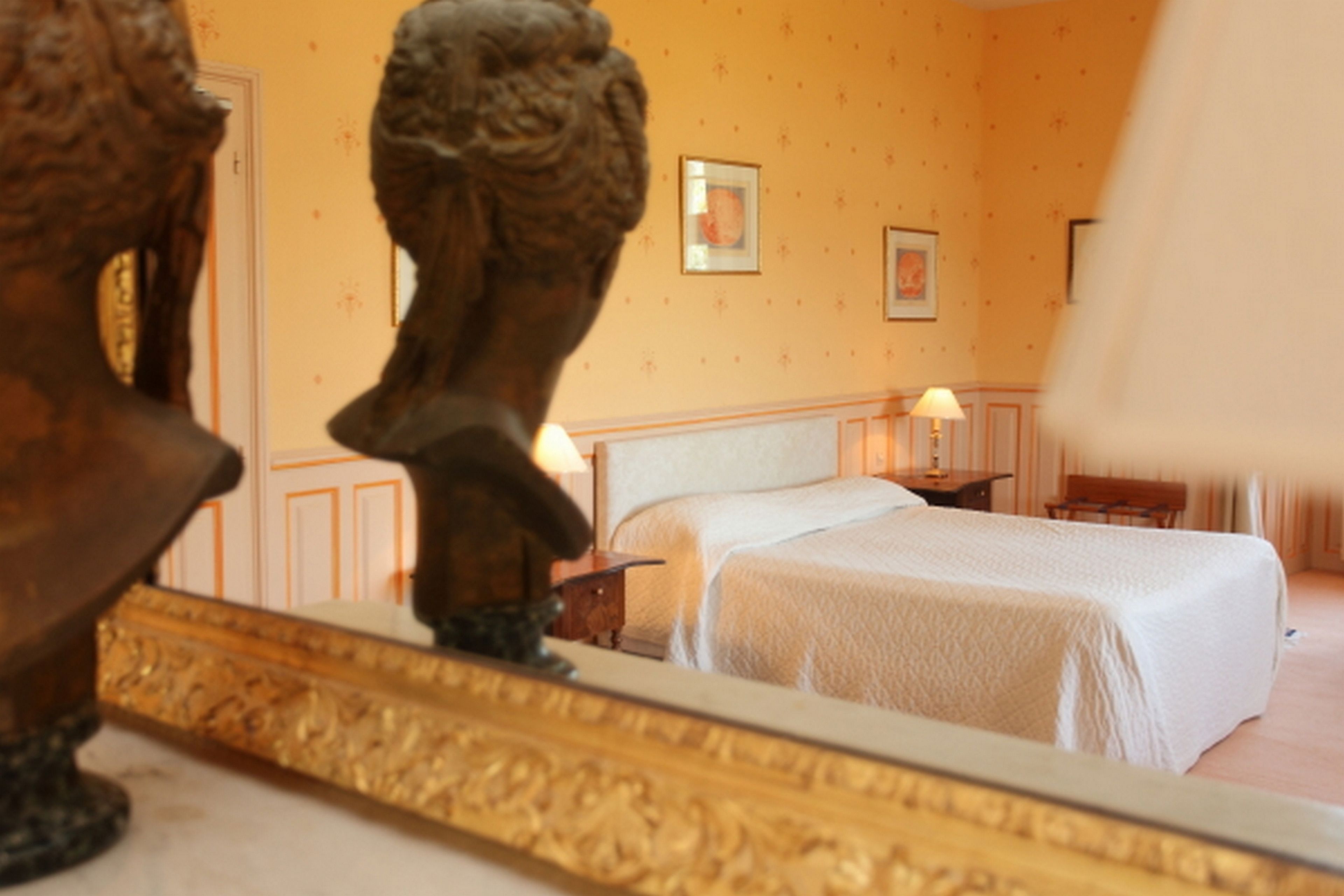A bedroom with a bed, a nightstand, and a lamp.