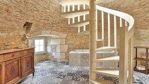 A room with a wooden vanity, a spiral staircase, and a patterned floor. - Hôtel & Spa Château de La Côte - Brantôme (Biras)