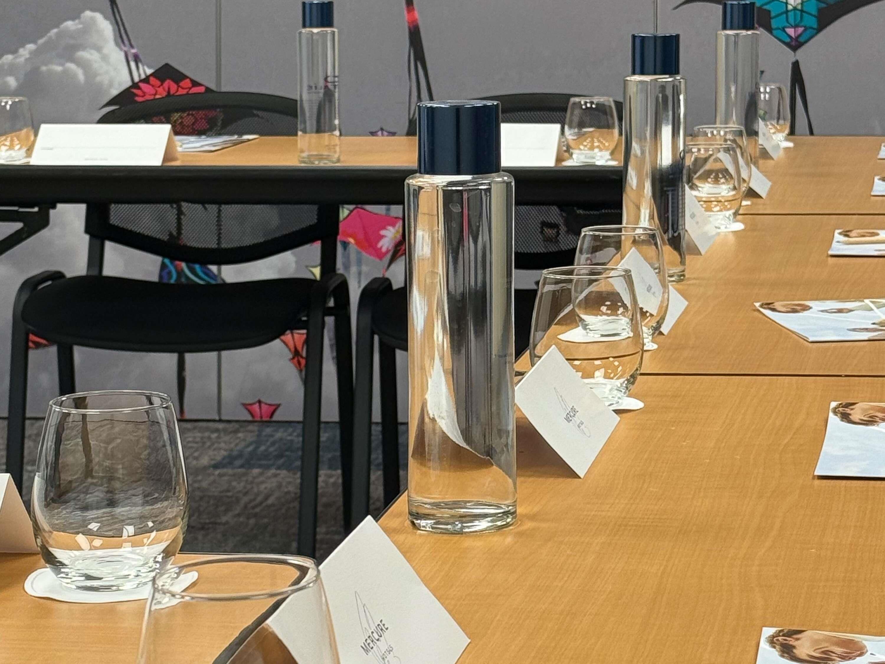 Et konferencelokale med navneskilte, glas og en vandflaske.