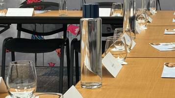 Et konferencelokale med navneskilte, glas og en vandflaske.