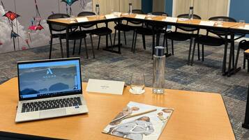 A conference room with a laptop, documents, and a water bottle on a table.
