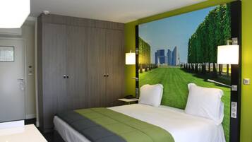 Una habitación de hotel con una cama grande, un armario, una mesita de noche y un mural en la pared con un paisaje urbano.
