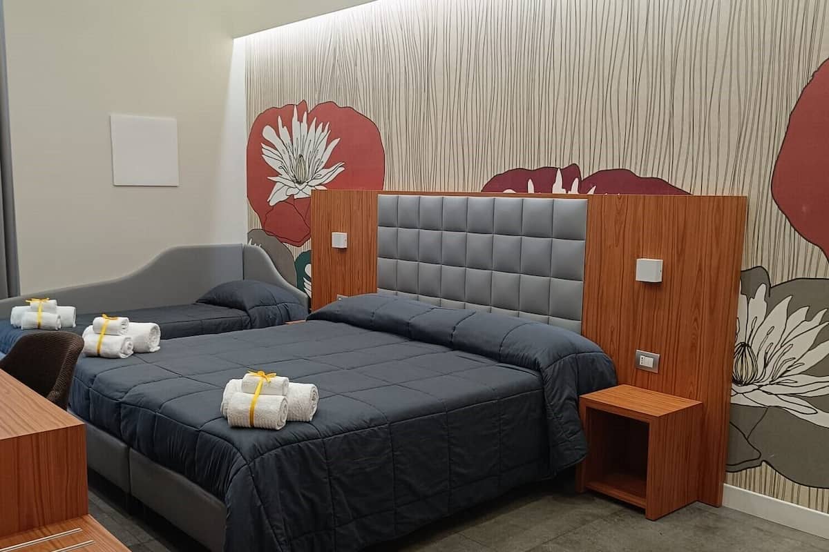 Una habitación de hotel moderna con una cama grande, un escritorio de madera y una pared decorada con un mural floral.