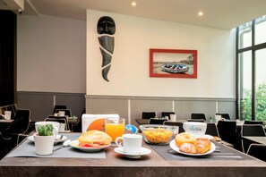 A breakfast table with a variety of food items, a coffee cup, and a glass of orange juice. - Villa Elisio Hotels & Spa (Naples)