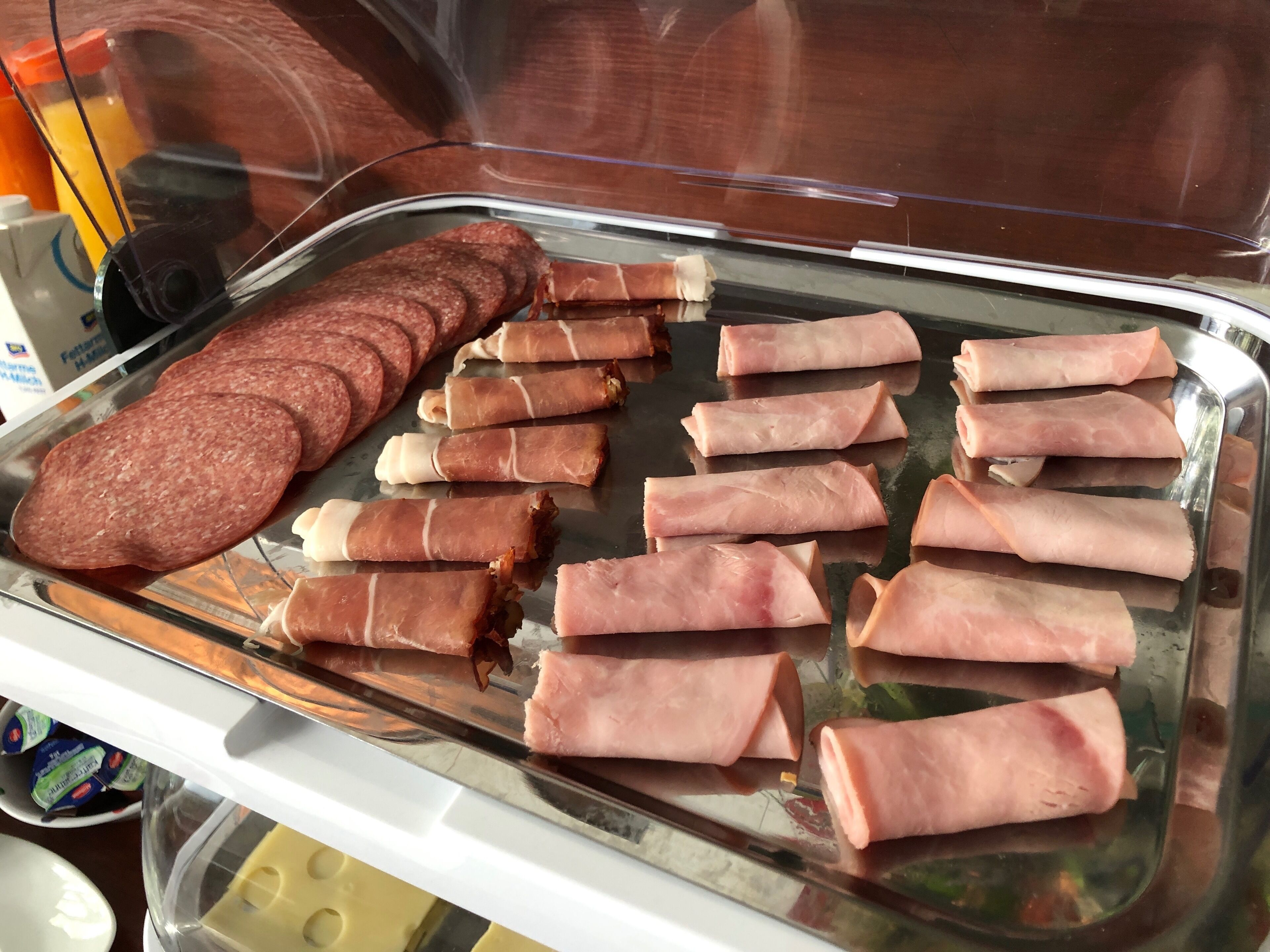 Een buffet met vleesschotels en kazen.