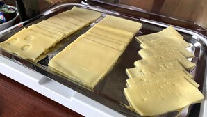 A display case with various cheese slices. - Hotel Aurelia (Frankfurt)
