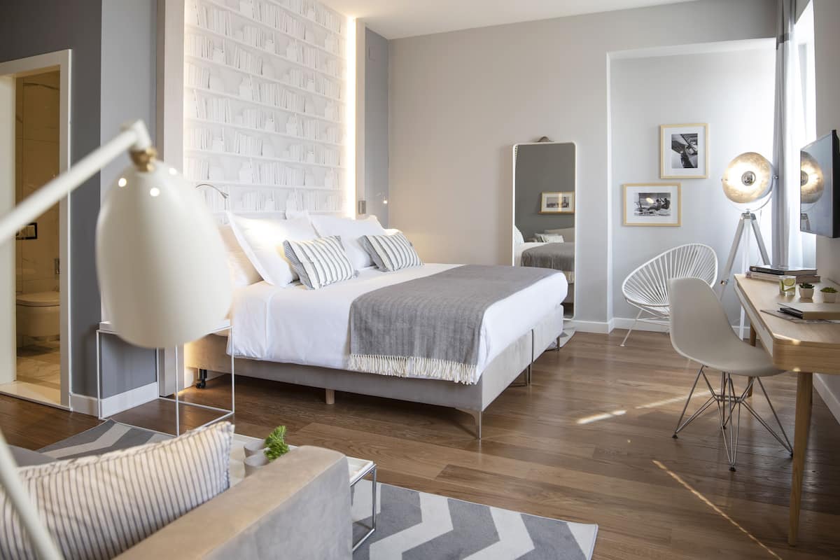 Une chambre à coucher moderne avec un lit, des tables de chevet, un bureau et une chaise.