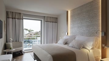 A modern hotel room with a large bed, a balcony with a view, and a patterned wall.