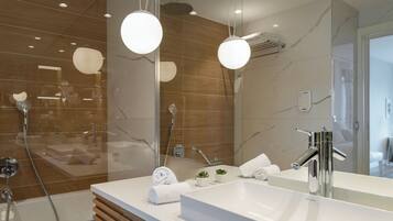 A modern bathroom with a large mirror, a white sink, and a shower area.