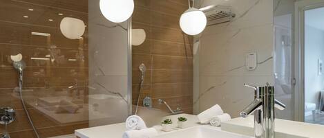 Une salle de bain moderne avec un grand miroir, un lavabo blanc et un espace douche.