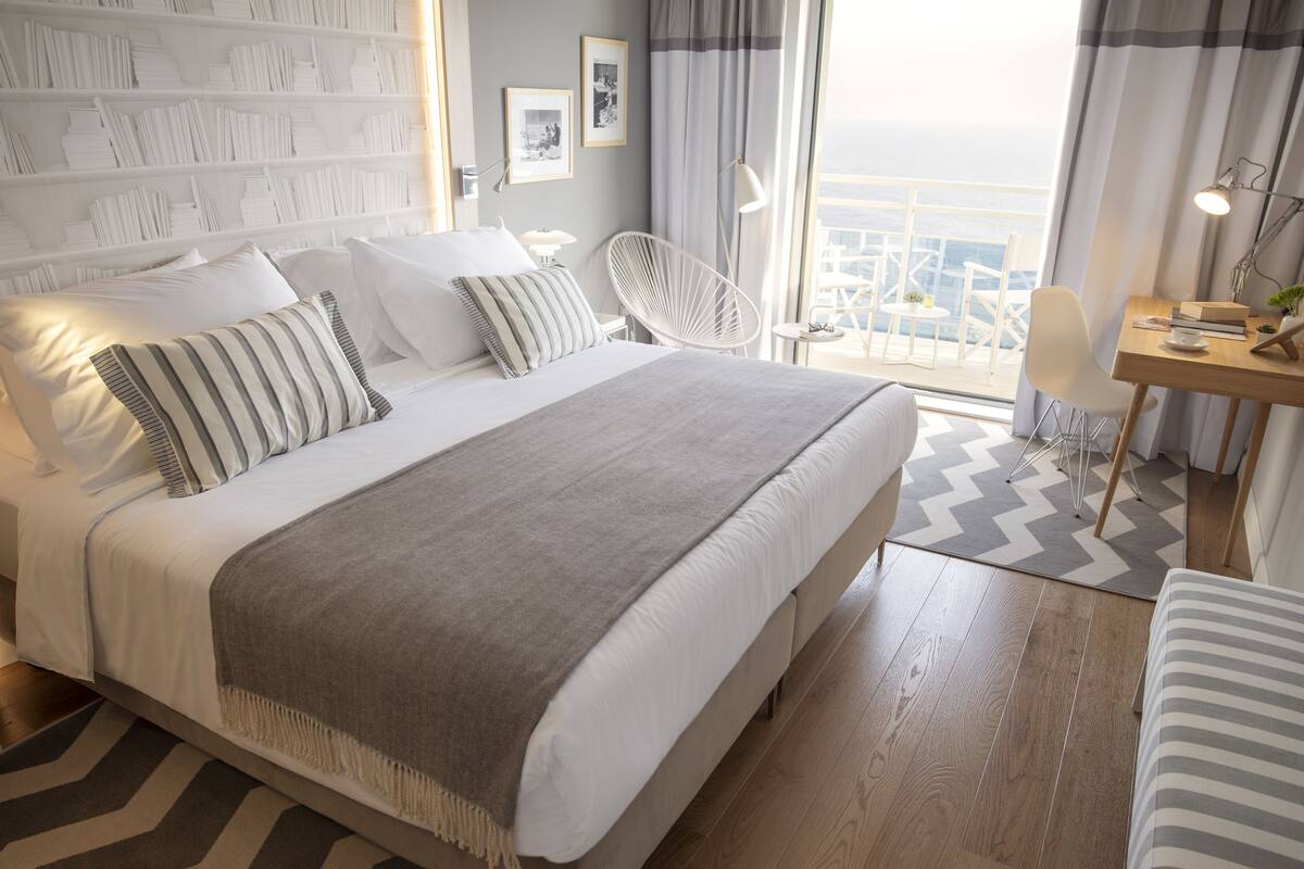 Une chambre d’hôtel moderne avec un grand lit, un bureau et une vue sur la ville.