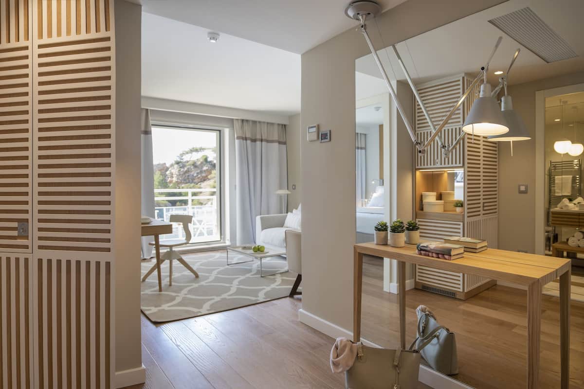 Une salle de bain moderne avec une paroi en verre, un plancher en bois et une vue sur l’extérieur.