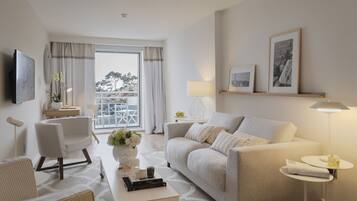 A modern living room with a sofa, armchairs, a coffee table, and a TV mounted on the wall.