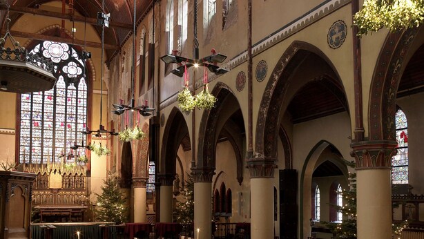 A large hall with long tables set for dining, arched ceilings, and a Christmas tree. - Monasterium PoortAckere (Ghent)