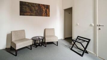 A room with two armchairs, a small round table, and a door.