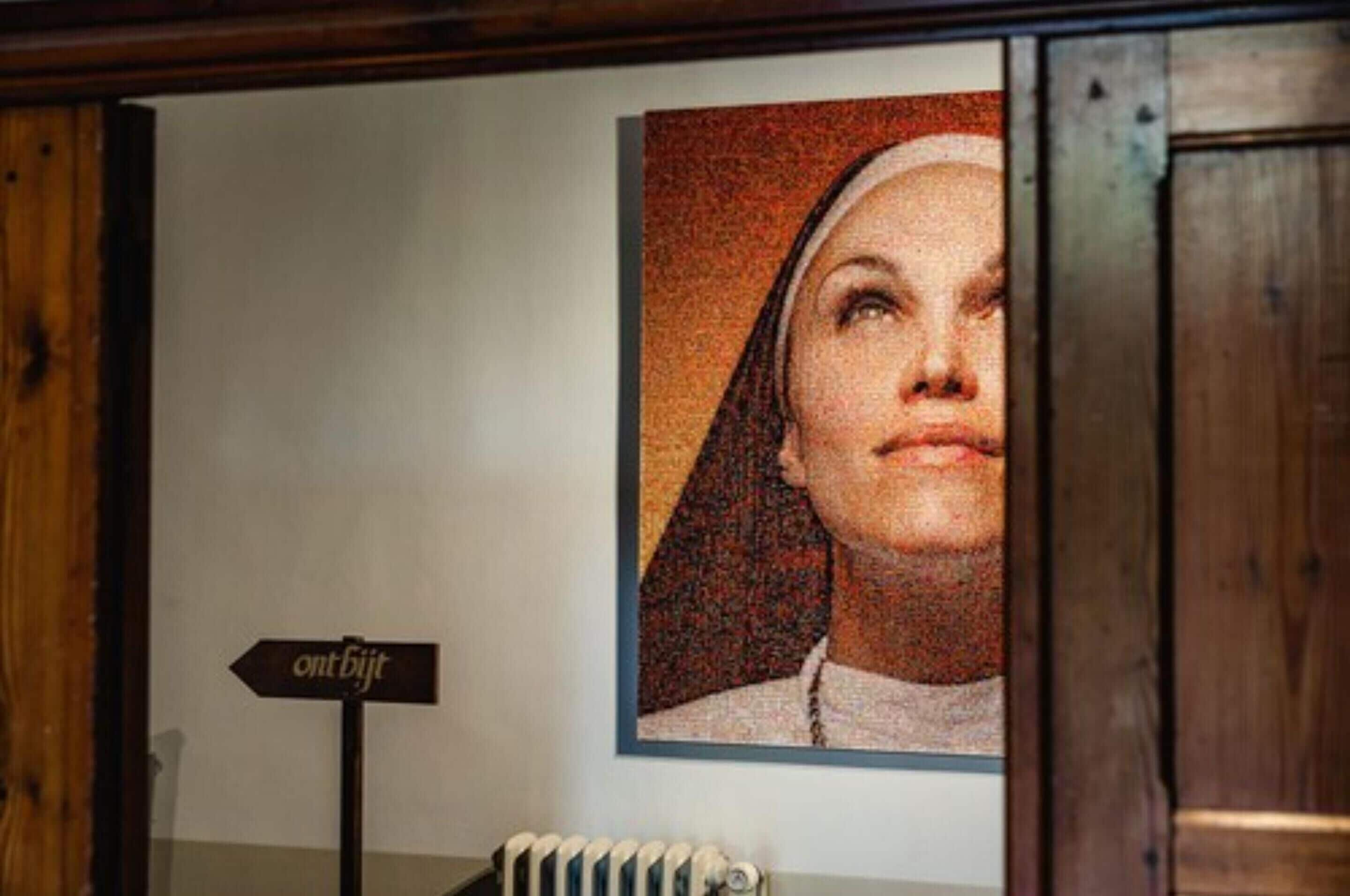 Un portrait encadré est accroché au mur, et un panneau indicateur se trouve en dessous.
