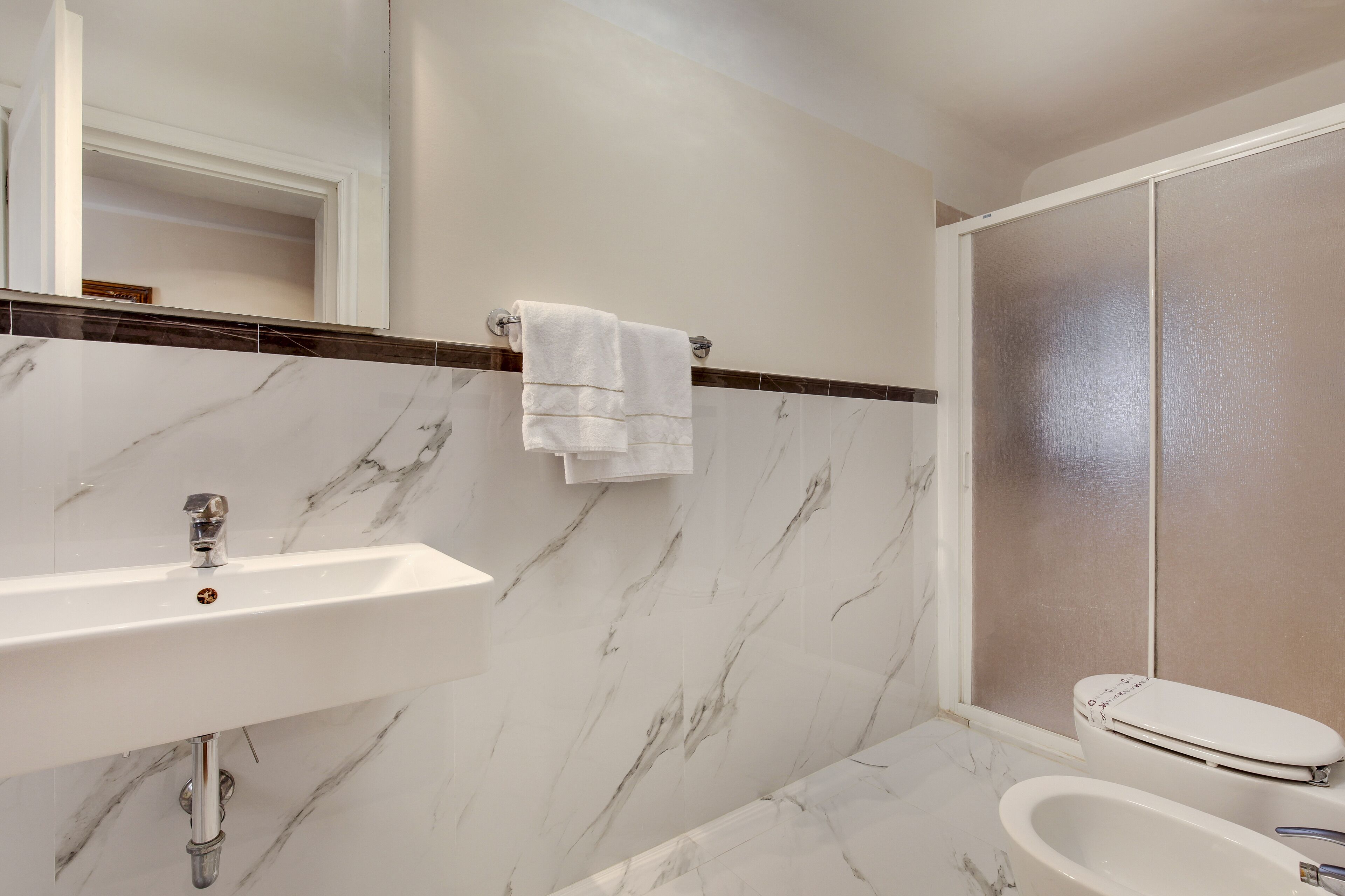 A bathroom with a white sink, a toilet, and a shower area.