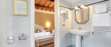 A bathroom with a sink, mirror, towel rack, and a framed certificate on the wall.