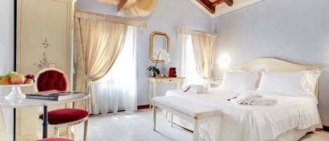 Una camera da letto con soffitto in legno, un letto con lenzuola bianche, un comodino con uno specchio e una sedia rossa.