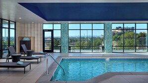 An indoor swimming pool with lounge chairs and a view of the city. - Fairfield Inn & Suites by Marriott Denver Downtown (Denver)