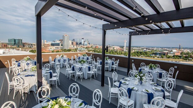 An outdoor rooftop venue with tables set for a formal event, featuring a city skyline view. - Fairfield Inn & Suites by Marriott Denver Downtown (Denver)