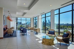 Un vestíbulo amplio con vistas a la ciudad, muebles modernos y ventanas grandes.
